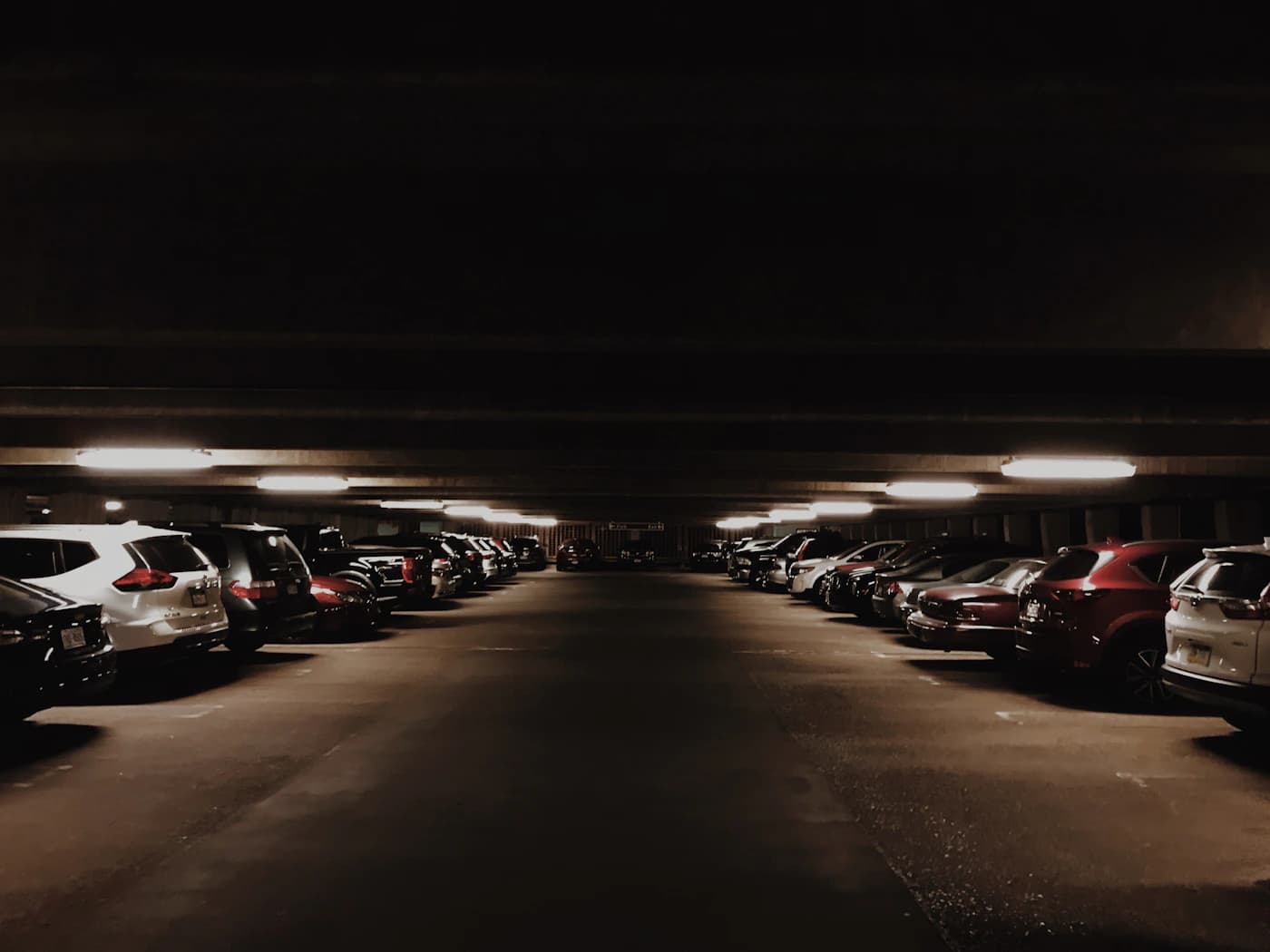 Structured commercial underground parking deck with organized vehicle bays and directional lighting